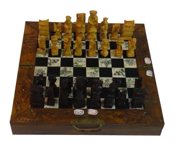 Um grande jogo de xadrez com base em madeira entalhada e uma grande peça de  xadrez esculpida