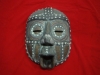Antiga máscara de cerimonial de tribo africana de "Benin" em madeira guarnecida com conchas e missangas. Alt.57cm.