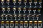 Aparelho com 81 peças em cristal da "Bohêmia", provavelmente "Moser", lapidado com navetes e mosaicos lavrados. Base octavada e corpo sextavado. Borda com faixa dourada. Composto de: 12 cálice de água, 12 cálices para vinho tinto, 12 cálices para vinho branco, 10 cálices para coquetel, 12 copos para whisky, 12 taças para champanhe e 11 cálices para licor. (Dois cálices de licor e 1 copo para whisky com leves bicados na borda e 1 cálice de coquetel colado na borda). Reproduzido com foto no catálogo.
