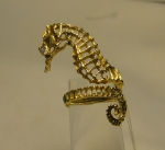 Diferente anel em ouro 18k no feitio de "cavalo marinho", guarnecido com 1 brilhante. Peso: 6,5g. Aro 6.