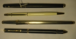 Quatro canetas esferográficas, sendo 2 da marca "Caran D'ache", e as outras das marcas "Corum" e "Charles Jourdan". Caixas em metal e baquelite.