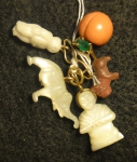 Cinco antigos berloques, sendo 3 em madrepérola e 2 em coral com guarnições em ouro 18k no feitio de "elefante, figuras, cãozinho e fruto".