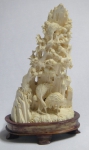Grupo escultórico em marfim representando "pássaros próximos ao rochedo com vegetação". Base oval em madeira clara. Alt.: 17cm. China - séc. XIX/XX.