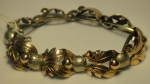 Antiga pulseira provavelmente portuguesa com detalhes florais de ouro baixo sobre prata cinzelada.
