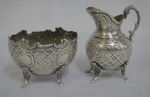 Pequena cremeira e bowl em prata baixa provavelmente alemã com decoração no estilo barroco-rococó. Alt. da cremeira: 7cm.
