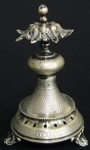 Paliteiro em prata Austro-Húngara contrastada, séc. XIX, em feitio de "roseta sobre coluna". Base e corpo finamente guilhochados. Pés em conchas. Alt. 10cm.