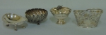 Três pequenos bowls diversos em prata europeia (sendo 1 no feitio de canoa), e 1 cestinha com alça em prata inglesa com borda fenestrada. Peso: 330g. (Falta o recipiente interno da cestinha).