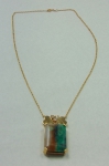 Gargantilha em ouro 18k com pendente em matriz de esmeralda baguete guarnecida com 2 corações e 3 brilhantes. Peso bruto: 16,6g.