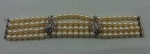 Elegante pulseira de 4 fios com 96 pérolas extras de 7mm. Guarnições e fecho em ouro branco com 75 brilhantes.