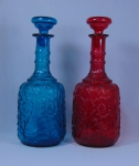 Par de antigos decanters em vidro moldado com decoração floral nas cores rubi e azul. Alt.: 30cm. (Em função da fragilidade, este lote só poderá ser enviado para fora do estado através de transportadora especializada).