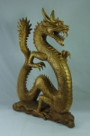 Divindade oriental esculpida em madeira revestida em dourado representando "Dragão". Alt.: 51cm.