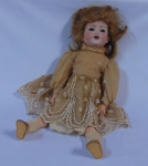 Antiga boneca alemã de coleção com rosto em biscuit. Vestes originais e cabelo verdadeiro. Apresenta marca na nuca. Alt.: 40cm.