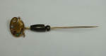 Antigo alfinete de gravata em ouro 18k no feitio de "paleta de pintor", com 1 brilhante e pedras brasileiras. Peso líquido: 2,0g.