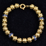 Pulseira portuguesa em ouro 19k - 800mls contrastada com contas trabalhadas, alternadas  com delicados esmaltes em azul e branco. Peso: 11,7g.