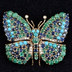 Extraordinário broche art nouveau no feitio de borboleta em ouro 18k com 26 brilhantes, esmeraldas e turquesas cabochon, e safiras redondas. Medida: 5,5 X 4,5. Peso: 40,3g.
