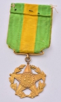 Medalha em ouro provavelmente 22k com símbolo da "República Brasileira" datada de 15 de novembro de 1901. Peso líquido: 11,1g. Diam.: 2,8cm.  Acompanha fita com as cores verde e amarelo.
