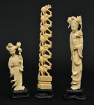 a) Duas figuras esculpidas em marfim, representando "Divindade Kuan Yin com flores". Base em madeira trabalhada. Alt.: 17cm e 12cm. China - 1900. b) Torre com 7 elefantes esculpidos em marfim. Base em madeira trabalhada. Alt.: 19cm. China - 1900.