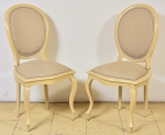 Par de cadeiras em madeira revestidas em decapé marfim estilo "Luis Felipe". Assento e encosto forrados em tecido bege.
