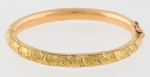 Antiga pulseira escrava oval estilo art nouveau em ouro 18k, provavelmente portuguesa, decorada com ramos e folhas. Peso: 16,3g. Larg. maior: 5,4cm.