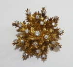 SIGSMUNDO GANSL - SÃO PAULO.  Esplêndido broche no feitio de ramos de flores em ouro 18k e 20 brilhantes, totalizando aproximadamente 1,50ct. Diam.: 4,2cm. Peso: 30g.