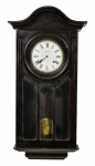 Relógio de parede da marca "Ansonia", modelo "Lisboa". Caixa original em madeira escurecida com frontão em meia lua. Mostrador esmaltado. Bate a cada hora e meia hora. Alt.: 94cm. E.U.A. - 1900. (Mecanismo necessitando de revisão).
