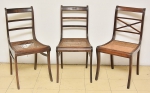Três cadeiras em mogno, sendo 2 formando 1 par, estilo "Regency", Inglaterra - 1900. Espaldares vazados, sendo 1 marchetado com treliça em "X". Pernas arqueadas. Assento em palhinha. (Dois assentos necessitando de revisão).