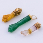 Três figas pendentes em marfim, jade e cristal com guarnições em ouro 18k. Comp. da maior: 3cm.