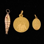 Três pingentes em ouro 18k, sendo, "peixinho articulado", "Nossa Senhora das Graças" e "Nossa Senhora da Conceição". Peso: 5,8g. (Falta rabo do peixinho).