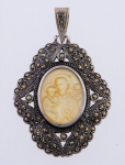 Antigo pendente sacro em marcassita filigranada, tendo ao centro imagem de "São José com Menino" em madrepérola. Comp.: 6cm.