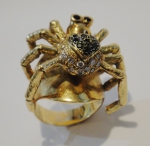 Magnífico anel no feitio de aranha em ouro 18k no feitio de aranha com 18 brilhantes brancos, 9 brilhantes negros e 2 rubis. Diam.: 3cm. Peso: 23,0g.