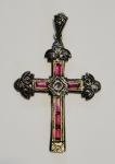 Antigo crucifixo provavelmente do séc. XIX, em prata sobre ouro com 3 diamantes e rubis carrés. Alt.: 4,5cm.