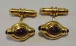 Par de abotoaduras italianas ovais em ouro 18k - 750mls contrastado, com rubi cabochon no centro e par de ônix cabochon nas extremidades. Comp.: 2,0cm. Peso: 15,5g.