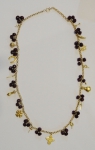 Magnífico colar com 14 berloques diversos, em ouro 18k, ornamentado com contas em rubi de aproximadamente 1cm. Comp.: 90cm. Peso líquido de ouro: 56g.