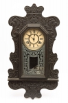 Relógio de parede da marca "Ansonia". Caixa em madeira entalhada dita "Capelinha". Alt.: 64cm. E.U.A - 1900. Funcionando.