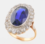 Antigo anel em ouro 18k, ouro branco com pedra azul oval central e 21 diamantes laterais. Aro: 13/14.