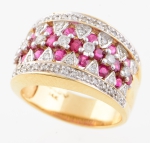 Elegante anel inglês em ouro 14k contrastado com 57 brilhantes intercalados com 22 rubis. Aro: 21. Peso: 10,6g.