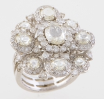 Magnifico anel em ouro branco no feitio de flor com 1 brilhante central oval, 30 brilhantes laterais, guarnecido por 88 diamantes. Aro: 15. Peso: 13,8g.