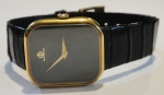 BAUME & MERCIER. Relógio feminino suíço de pulso da marca "Baume & Mercier". Caixa em ouro 18k contrastado. Movimento a corda. Arremate da coroa com safira azul. Pulseira original em couro. Medida da caixa: 3,0 X 2,0. Funcionando.
