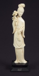 Figura esculpida em marfim, representado "Divindade Kuan Yin com flor de lótus". Base em madeira. Alt.: 23cm. China - 1900.