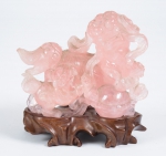 Figura esculpida em jade rosa, representando "Cão de fó". Base em teca entalhada. Alt.: 14cm. Comp.: 14cm. China - 1900. (Apresenta alguns lascados). (Em função da fragilidade, este lote só poderá ser enviado para fora do estado através de transportadora especializada).
