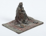 Escultura miniatura em bronze austríaco policromado do séc. XIX, representando "Beduíno sobre tapete oriental". Comp.: 6cm.