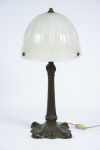 Abajur art nouveau em bronze trabalhado no estilo. Base e coluna quadrangulares. Cúpula em opalina na cor branca canelada. Alt.: 58cm. Europa-1940.