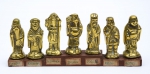 Grupo com 7 figuras em bronze dourado, representando " Os 7 Deuses da felicidade (Benzaiten, Bishamon, Daikoku, Ebisu, Jurojin, Hotei, Fukurokuju)". Acompanha base em madeira. Japão - 1900. Comp.: 22cm.