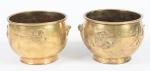 Par de vasos cilíndricos em bronze dourado decorados em alto relevo com "pássaros e vegetações diversas". Alt.: 10cm. Diam.: 12,5cm. Marca do período no fundo.
