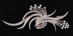 Delicado broche em platina dos anos 50, no feitio de "ramo", com 50 brilhantes diversos. Comp.: 8cm. Peso: 13,6g.