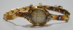 Relógio feminino suíço de pulso dos anos 50, da marca "Rotos". Caixa e pulseira em ouro 18k contrastado, ouro branco e 2 diamantes. Movimento a corda. Peso: 10,1g. Funcionando.