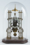 Antigo e raro relógio dito "Esqueleto", provavelmente alemão, estilo Gótico. Estrutura em bronze. Mostrador esmaltado. Base em madeira. Cúpula em vidro moldado. Alt.: 51 cm. Funcionando. Reproduzido com foto no catálogo.