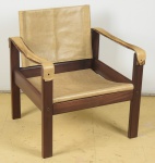 Poltrona em madeira maciça, provavelmente atribuída à "Sergio Rodrigues", estrutura e travessas retas (circa 1960). Braço e percintas em couro. Assento e encosto em courino.