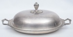 Travessa coberta oval para assado, espessurada a prata ornamentada no estilo inglês. Puxador no feitio de pinha. Medida: 50 X 35.