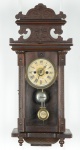 Relógio de parede americano (circa 1900). Caixa em madeira com entalhes e lavrados diversos. Mostrador com desgaste do tempo. Alt.: 57 cm. (Mecanismo necessitando de revisão).
